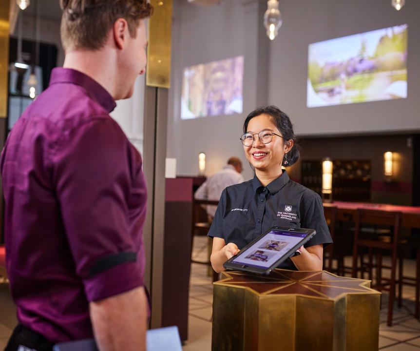 concierge with a tablet welcoming a guest 