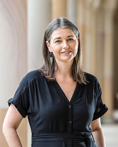 Profile photo of Dr Cassandra Chapman standing in UQ's Great Court