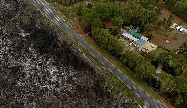 A road revents a bushfire from burning a house in New South Wales. Containment lines reinforced by the rural fire service save a home