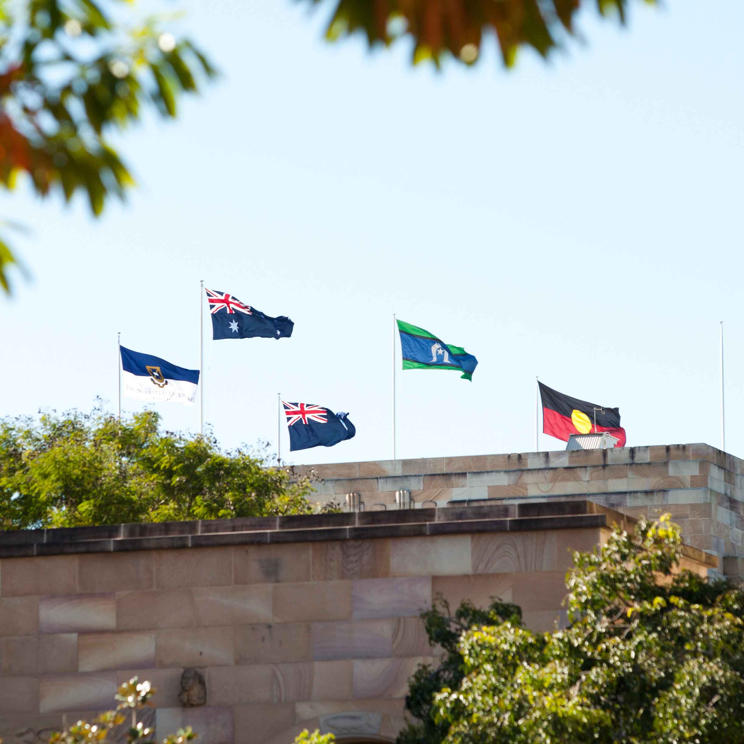 This is an image of several flags on the roof of the Forgan Smith building at UQ