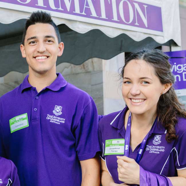 2 smilin gstudents at open day wearing UQ purple polos