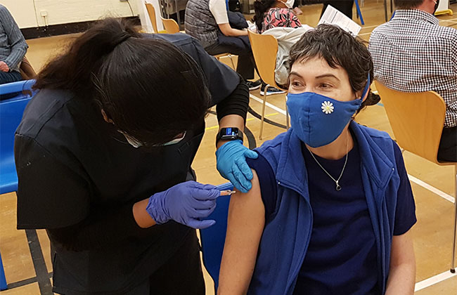 A woman happily receiving the COVID-19 vaccination.