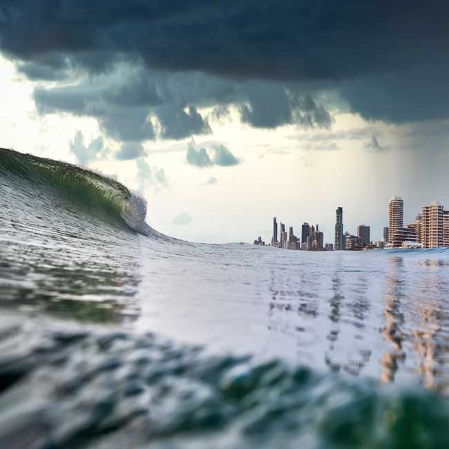 large wave with dark clouds, Surfers Paradise in the background