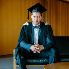 The Bachelor of Commerce/Economics graduate sitting in graduation gown