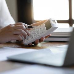 Accountant using calculator to calculate taxes