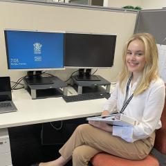 UQ student Stephanie Grob sitting at a desk during work placement at Queensland Health